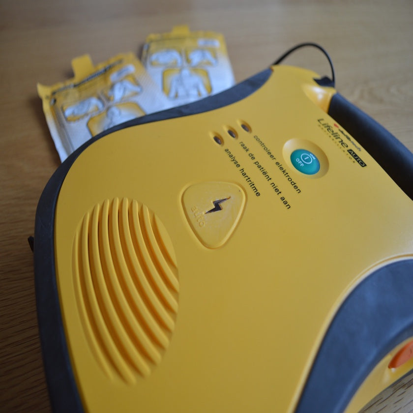A photo of a yellow and black AED device