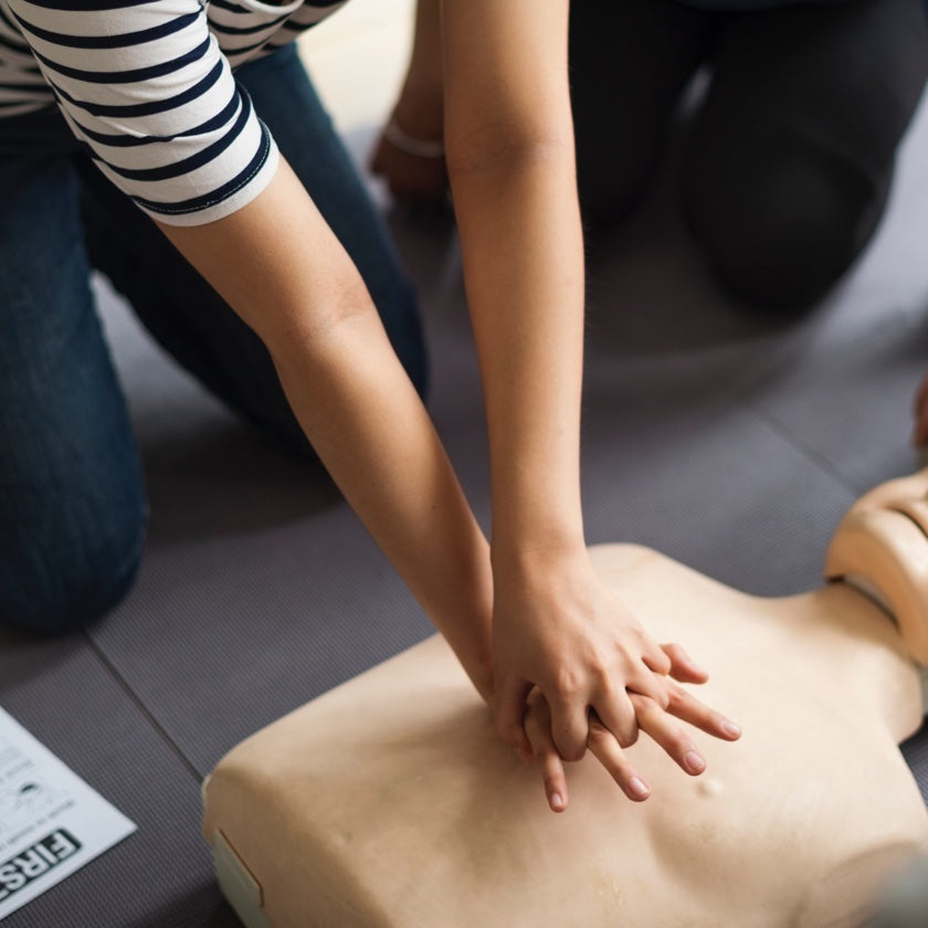 Person practicing cpr on a training mannequin