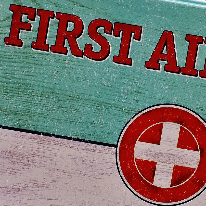 A sign with the first aid text and cross
