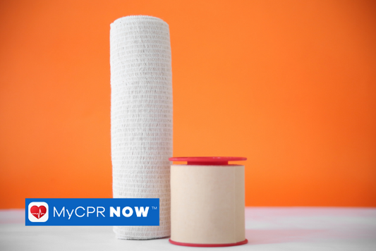 A roll of gauze and a roll of medical tape on a white surface with an orange background.