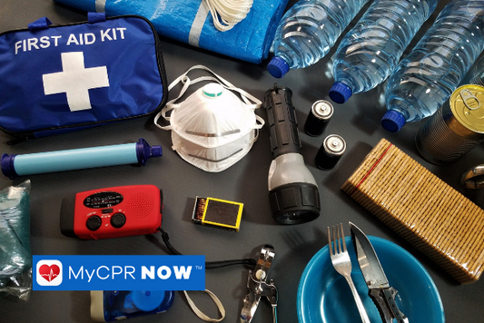 A first aid kit with a flashlight, bottled water, and essential items for emergencies