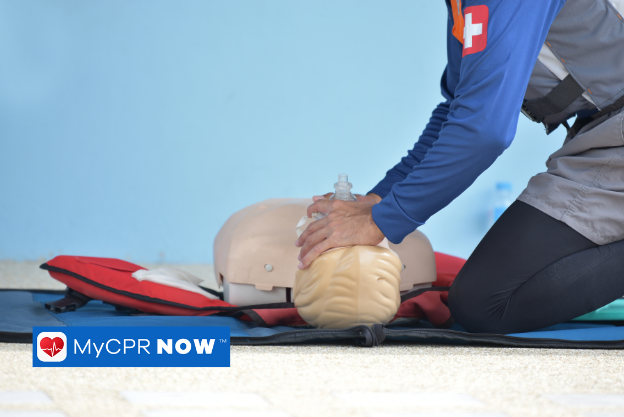 A medical professional practicing mouth-to-mouth resuscitation on an infant mannequin.