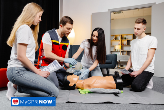 A group of people practicing CPR on a training mannequin under the guidance of an instructor.