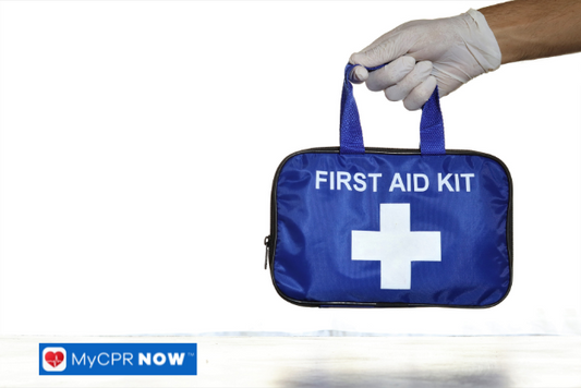 Blue first aid kit held by a gloved hand against a white background.