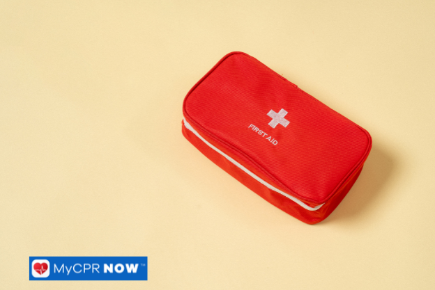 A red first aid kit placed on a neutral beige background.