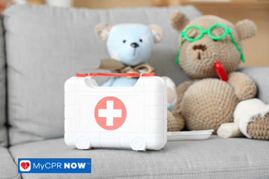 White plastic first aid kit on a couch with teddy bears in the background.