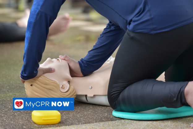 Rescue worker performing CPR with a bag-valve mask on a mannequin.
