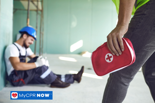Injured worker with someone approaching with a first aid kit.
