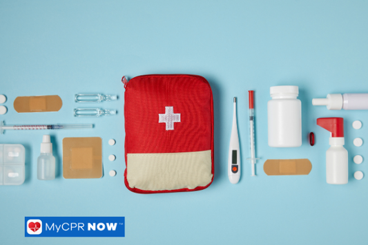 A red first aid kit surrounded by scattered medical supplies on a blue background.