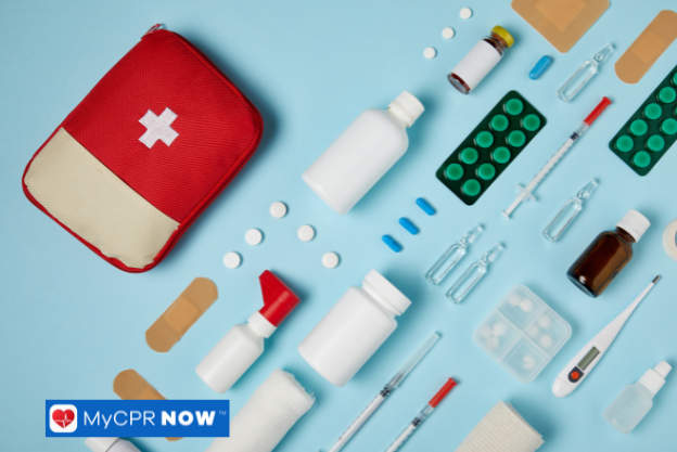 A red first aid pouch surrounded by bandages, syringes, pills, and medical equipment on a blue background.
