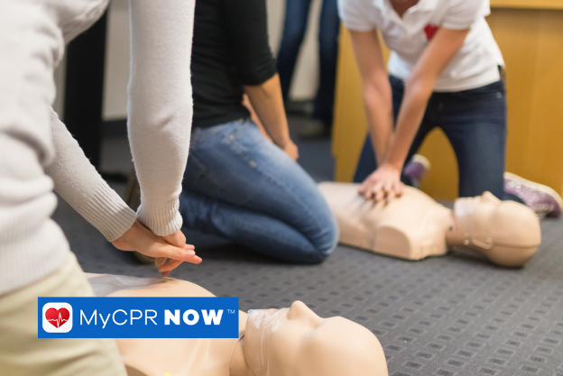 A group of three people inside practicing chest compressions on adult CPR mannequins. 