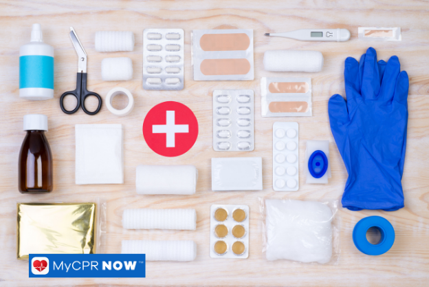 Assorted first aid supplies neatly arranged on wooden surface.