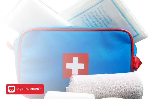 A blue and red first aid kit with supplies around it and a white background. 