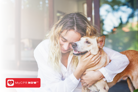 A woman in a white shirt hugging a medium size dog.