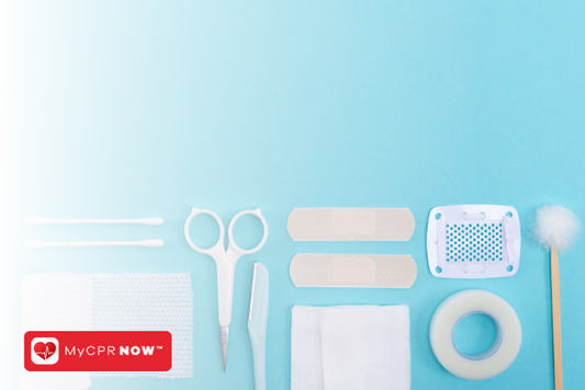 First aid supplies like swabs, scissors, a scalpel, adhesive bandages, and medical tape on a light blue background. 