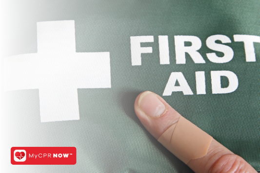 Someone's bandaged finger on a green first aid kit with white letters and a white cross.  