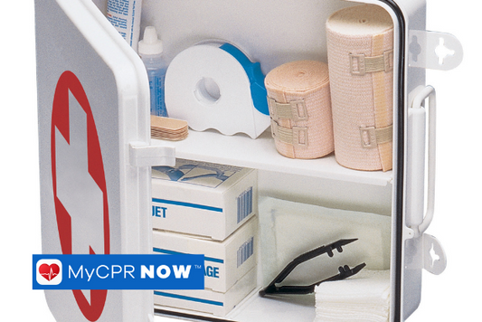 A open white first aid kit, with supplies in it such as medical tape, ace bandage, gauze, and tweezers. 