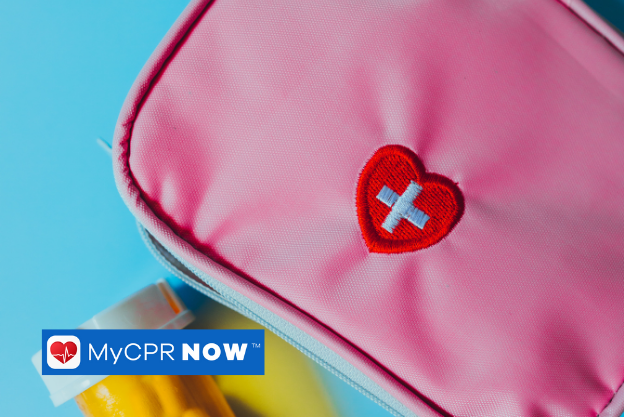 A pink first aid kit with a pill bottle next to it on a blue background. 