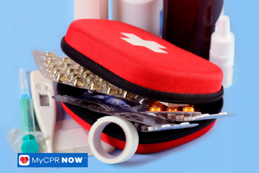 Compact red first aid kit with assorted medical items including pills and a thermometer.