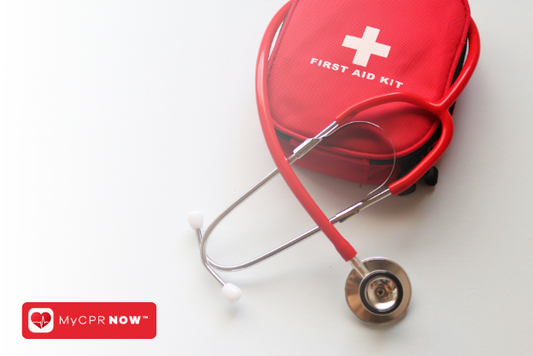 A red first aid kit with a red stethoscope on a light surface. 