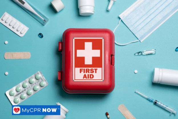 A red first aid kit with a white cross, surrounded by medical items such as bandages, pills, syringes, and a mask on a blue background.