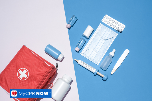 Red first aid kit and medical supplies arranged on a blue and white background.