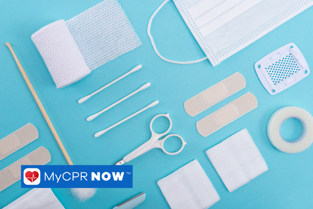 First aid supplies like swabs, scissors, medical tape, mask, gauze, and bandages on a blue background. 