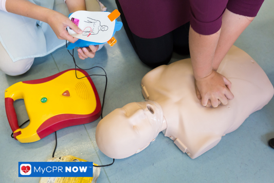 CPR training with AED demonstration on a manikin.