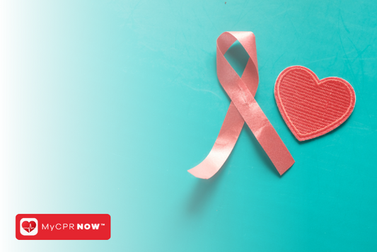 A pink silk ribbon and a red paper heart against a teal background. 