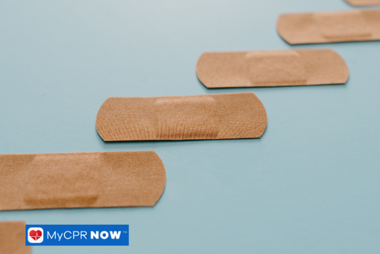 Bandages on blue background – Several adhesive bandages arranged neatly on a light blue background.
