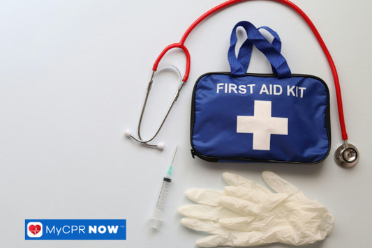 Blue first aid kit with stethoscope – A blue first aid kit with gloves, a syringe, and a stethoscope beside it.