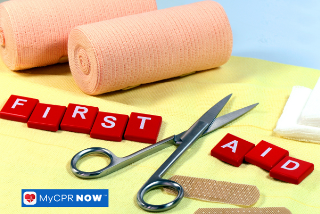 First aid supplies with red lettering – First aid bandages, scissors, and supplies with red blocks spelling “FIRST AID.”