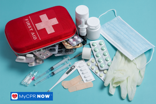 A red first aid kit opened with various medical supplies, including pills, gloves, and bandages, arranged on a blue background.
