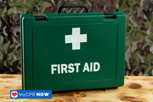Green first aid kit on a wooden surface with camouflage background.