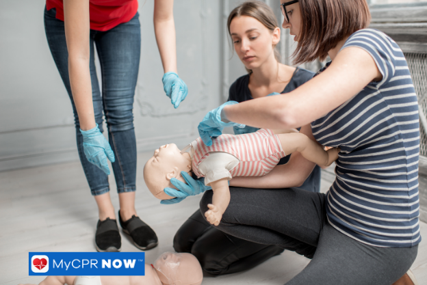 Person performing CPR on an infant dummy.