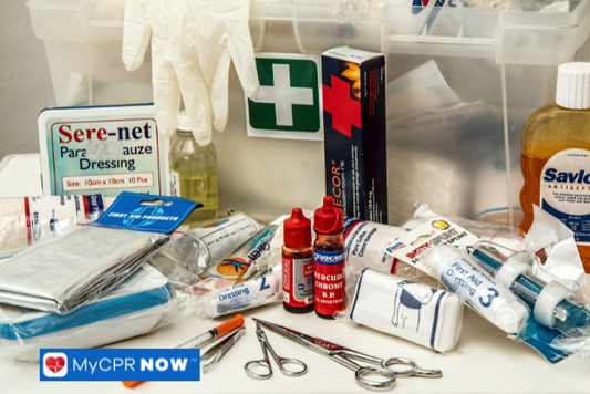 Assorted medical supplies and medications in an open emergency first aid box.