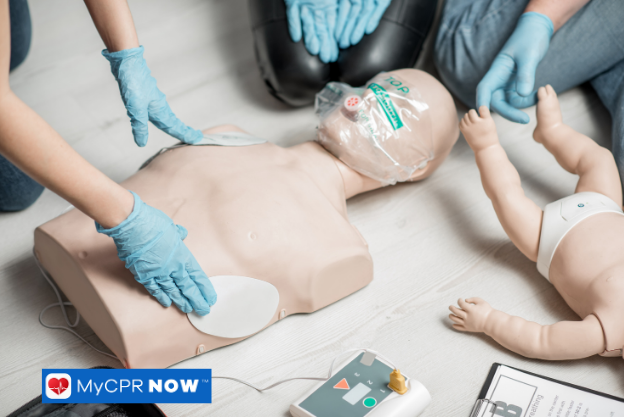 CPR training manikin with defibrillator pads applied next to an infant manikin.