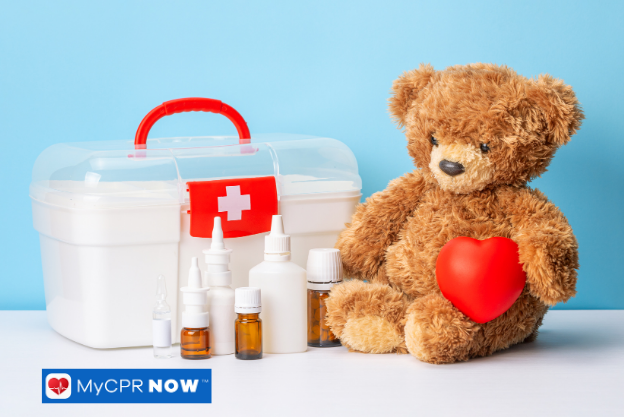 Teddy bear with a heart next to a white first aid box and medicine bottles