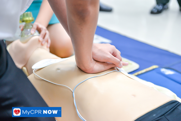 Person doing chest compressions on a CPR mannequin.