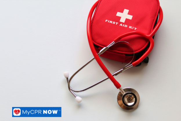 First aid kit with a stethoscope on a white surface.