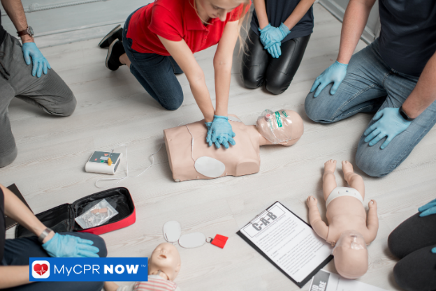 Close-up of a person performing chest compressions on a CPR manikin.
