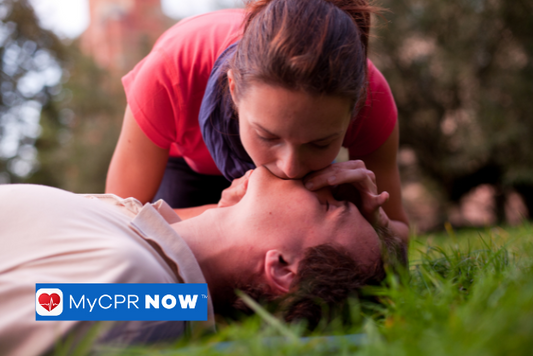 A woman performing rescue breathing on an injured man