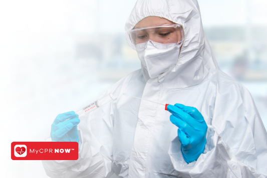 Someone wearing PPE such as gloves, mask, and protective glasses, holding a dropper and test tube. 