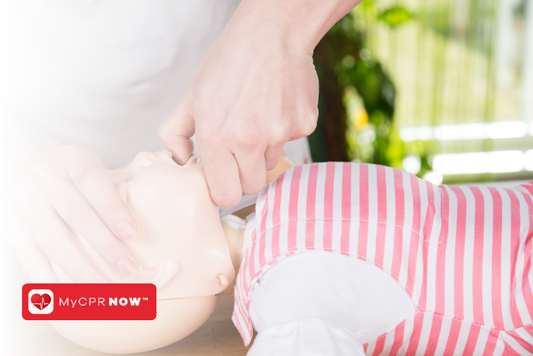 A close up of someone tilting back the head of a child CPR mannequin. 