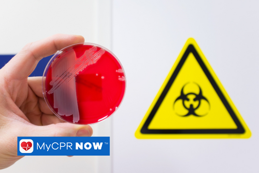 Someone holding a petri dish with something red in it with a biohazard sign behind them. 