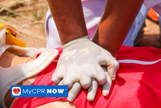 Someone wearing latex gloves giving someone in a red shirt and a neck brace CPR. 