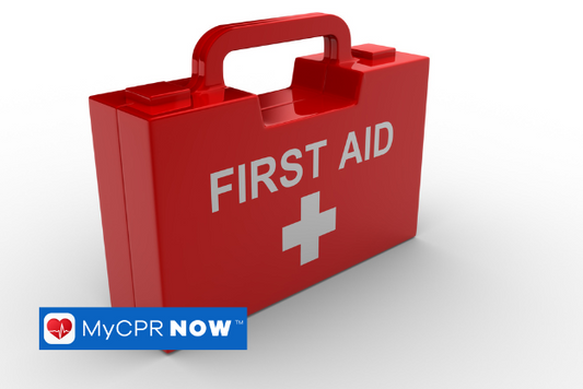 Red first aid kit with white letters with a white cross on a white surface. 