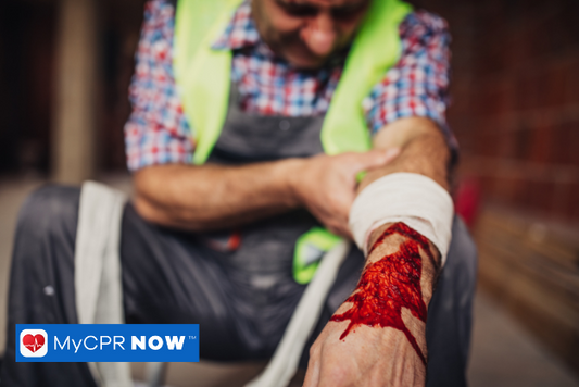 A man in a checkered shirt with sleeves rolled up, jeans, and a yellow vest. His left arm has an injury held by a bandage on his left hand.