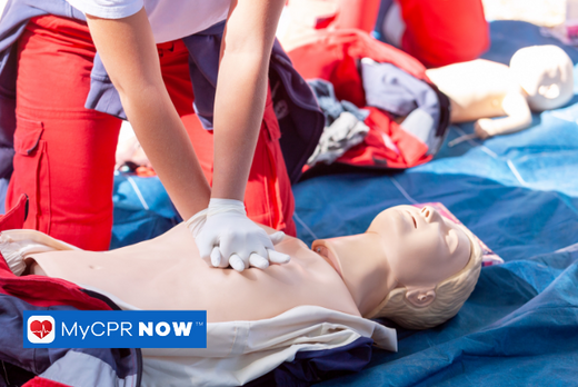 A person performing CPR on a manikin training aid 