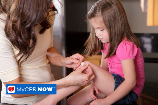 A mother puts a bandage on their child's knee